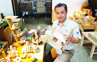 木のおもちゃを手にする営業部長の酒井慶太郎さん